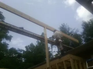 Carpenter setting a ridge beam over a new addition frame — Ice Dam Removal by Roofing Brothers in Mc Caysville